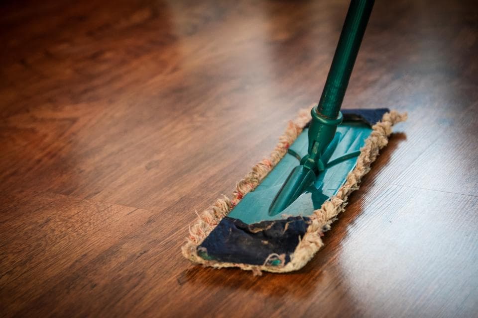 Professional cleaner mopping a modern home floor in Singapore