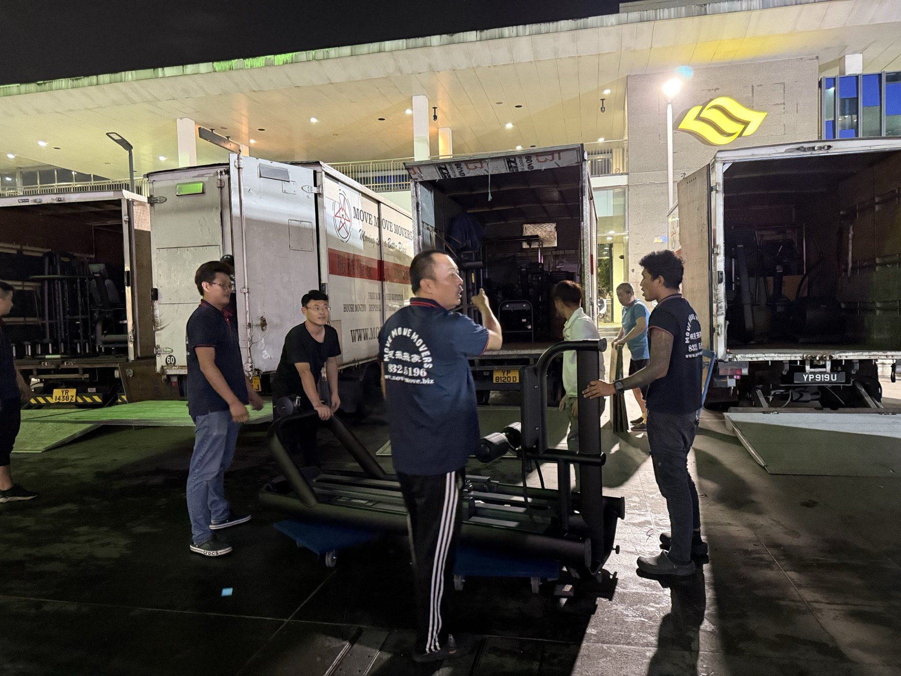 Commercial moving crew loading branded lorries at night for after-hours execution